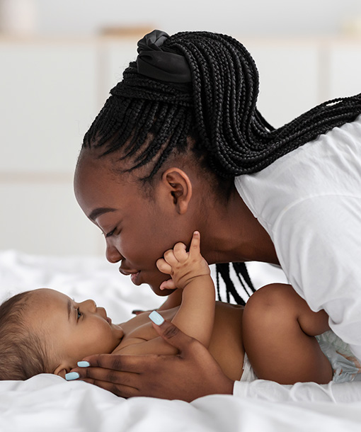 Portrait Photo of African Woman Being a Caregiver and showing Love to a Baby Boy at Petite Crew